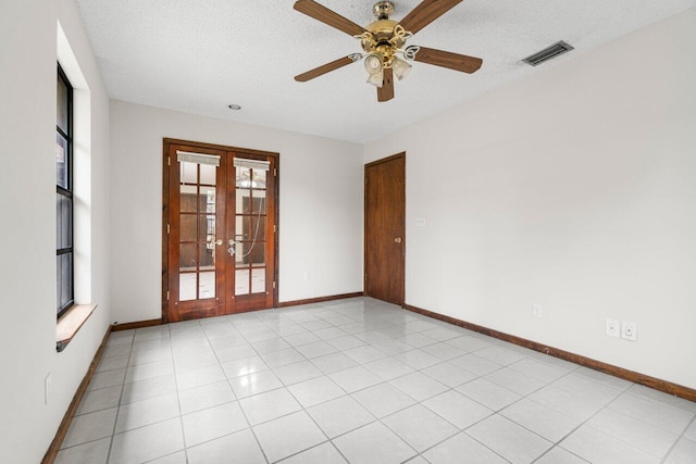 empty room featuring french doors, visible vents, and baseboards