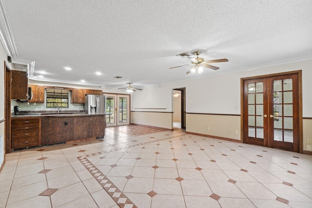 kitchen with french doors, crown molding, baseboards, and stainless steel fridge with ice dispenser