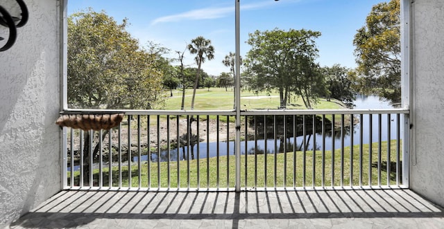 balcony with golf course view and a water view