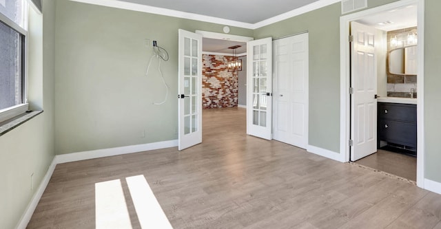 unfurnished bedroom with visible vents, ornamental molding, wood finished floors, french doors, and baseboards