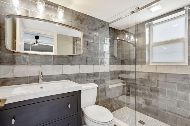 bathroom featuring a stall shower, toilet, vanity, and a ceiling fan