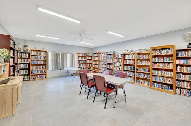 interior space featuring a ceiling fan and wall of books