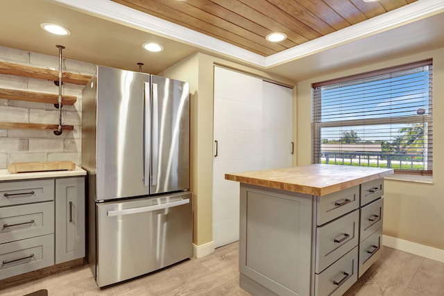 kitchen featuring gray cabinetry, freestanding refrigerator, light wood-style floors, butcher block counters, and wood ceiling