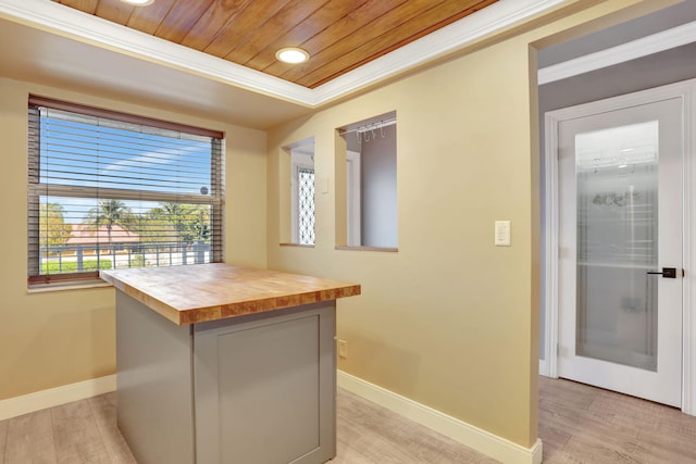 kitchen featuring crown molding, baseboards, butcher block counters, wooden ceiling, and light wood-style floors