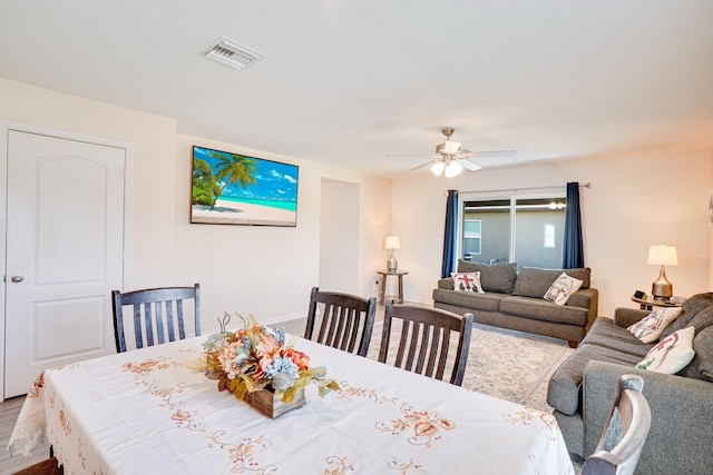 dining area with visible vents, wood finished floors, and a ceiling fan