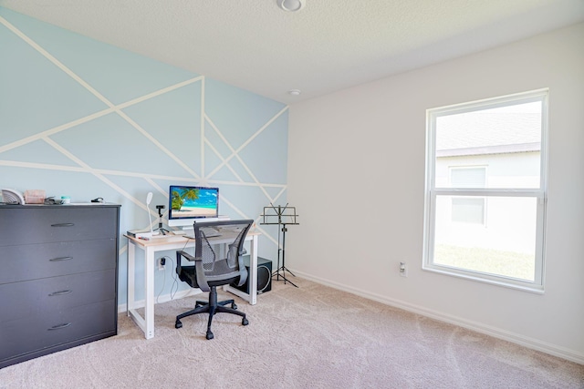 office area with a textured ceiling, baseboards, and carpet