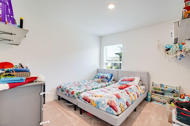 carpeted bedroom with a textured ceiling and baseboards