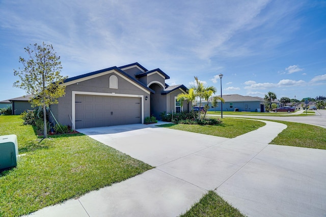 view of front of property with stucco siding, an attached garage, concrete driveway, and a front yard