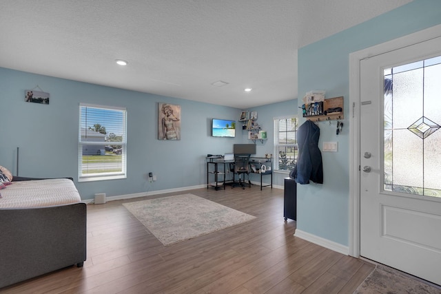 foyer entrance with recessed lighting, baseboards, and wood finished floors