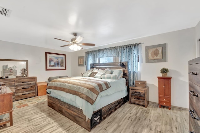 bedroom with light wood-type flooring, visible vents, and ceiling fan