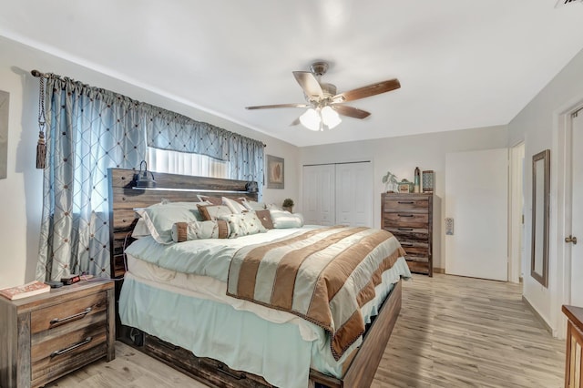 bedroom with a closet, a ceiling fan, and light wood-style floors