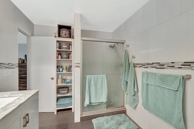 full bathroom featuring vanity, wood finished floors, and a stall shower