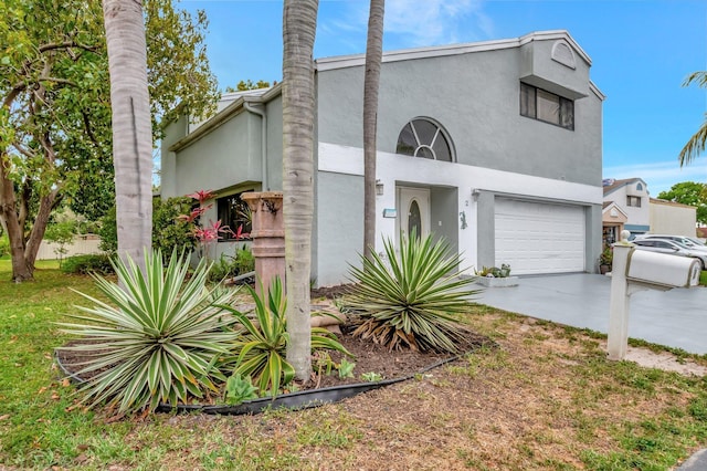 view of front of home with stucco siding, concrete driveway, and an attached garage