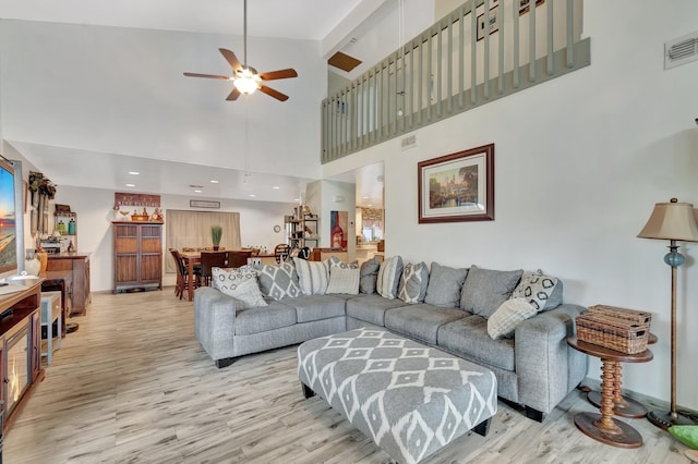 living area featuring visible vents, light wood-style flooring, and a ceiling fan