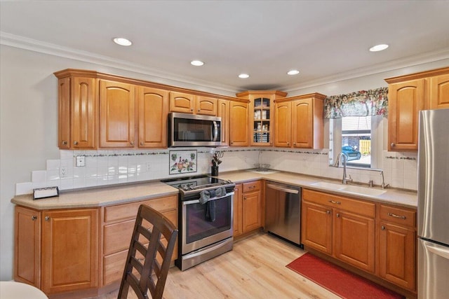 kitchen with glass insert cabinets, appliances with stainless steel finishes, decorative backsplash, and light wood finished floors