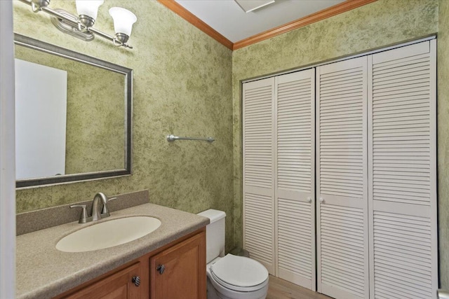 bathroom with a closet, toilet, ornamental molding, and vanity