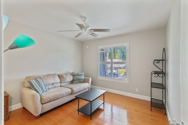 living area with light wood finished floors, ceiling fan, and baseboards