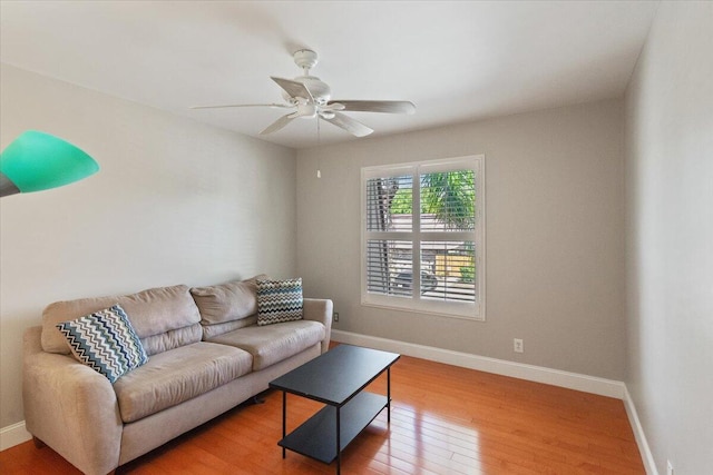 living room with baseboards, ceiling fan, and hardwood / wood-style flooring