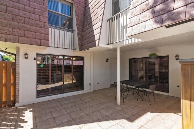 view of patio featuring outdoor dining area and a balcony