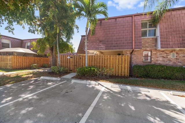 uncovered parking lot with a fenced front yard