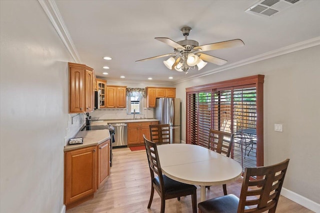 dining room with crown molding, visible vents, and a wealth of natural light