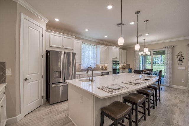 kitchen featuring visible vents, a sink, a large island, appliances with stainless steel finishes, and light wood-type flooring