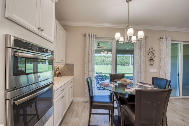 dining area featuring light wood-type flooring, baseboards, a notable chandelier, and ornamental molding