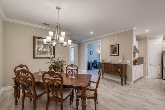 dining space featuring visible vents, ornamental molding, an inviting chandelier, light wood finished floors, and baseboards