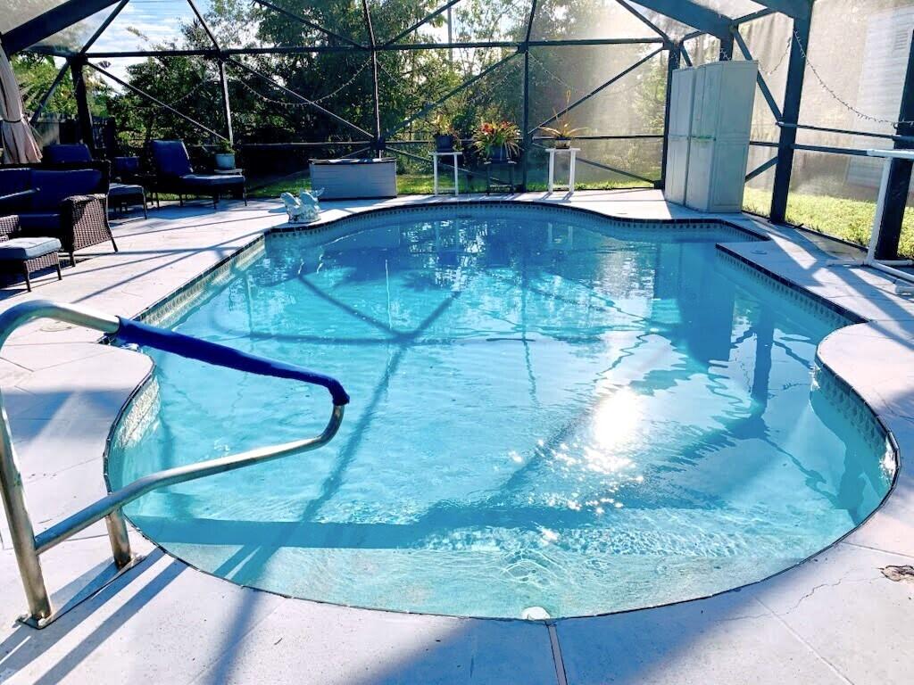 view of pool featuring a patio area, glass enclosure, and a fenced in pool