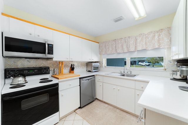 kitchen with tasteful backsplash, range with electric cooktop, light countertops, stainless steel dishwasher, and a sink
