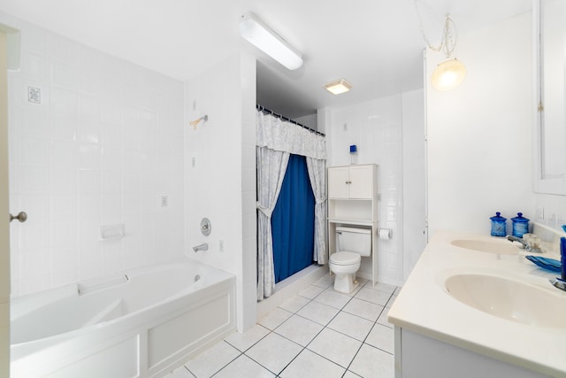 bathroom featuring tile patterned floors, toilet, double vanity, and a sink