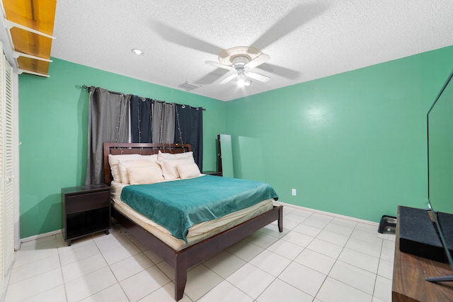 bedroom featuring light tile patterned floors, a ceiling fan, visible vents, and a textured ceiling