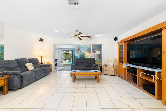 living area with light tile patterned floors, visible vents, and ceiling fan