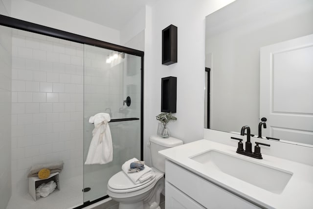 full bathroom featuring tiled shower, toilet, and vanity