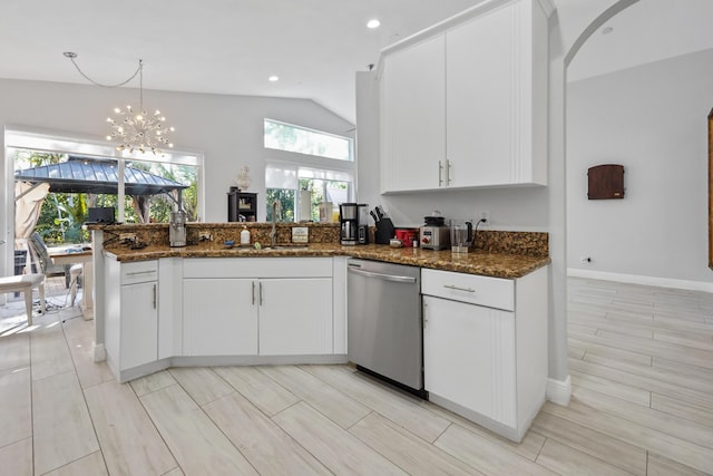 kitchen with white cabinetry, dark stone counters, a peninsula, a sink, and stainless steel dishwasher