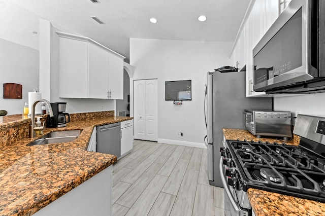 5822 Saddle Trail Ln, Lake Worth, FL 33449 - kitchen featuring appliances with stainless steel finishes, white cabinets, dark stone countertops, wood finish floors, and arched walkways