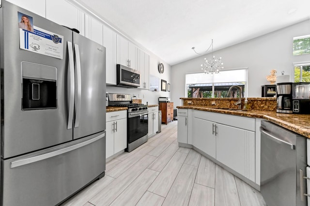 5822 Saddle Trail Ln, Lake Worth, FL 33449 - kitchen with stainless steel appliances, vaulted ceiling, plenty of natural light, a chandelier, and white cabinetry