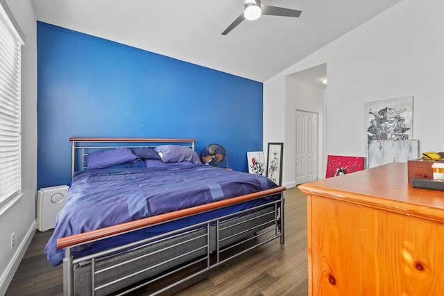 bedroom with baseboards, lofted ceiling, and wood finished floors