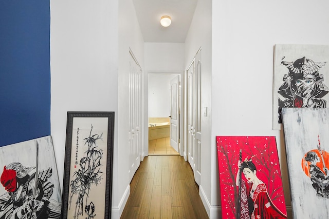 hall featuring baseboards and hardwood / wood-style flooring