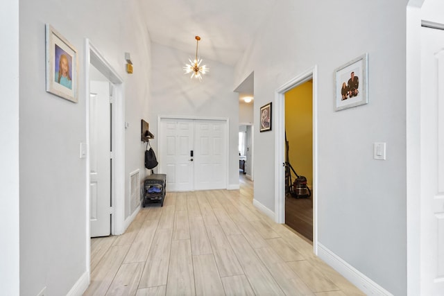 5822 Saddle Trail Ln, Lake Worth, FL 33449 - entryway with light wood-style flooring, high vaulted ceiling, and a chandelier