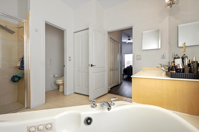 ensuite bathroom featuring tile patterned flooring, a tub, toilet, a stall shower, and vanity