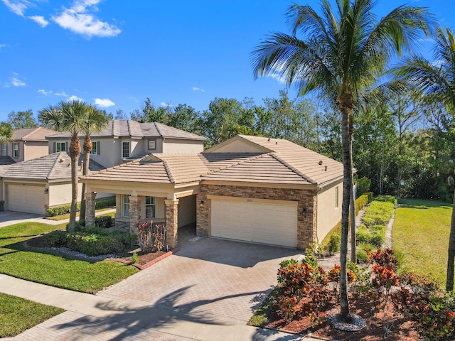 view of front of home featuring an attached garage, stucco siding, a front lawn, stone siding, and decorative driveway