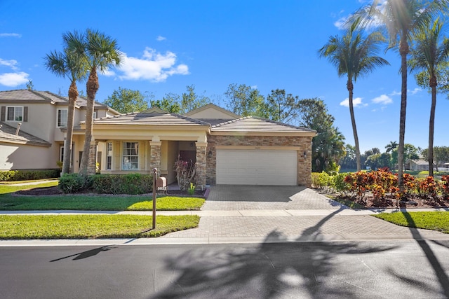 view of front facade featuring stucco siding, decorative driveway, stone siding, an attached garage, and a tiled roof