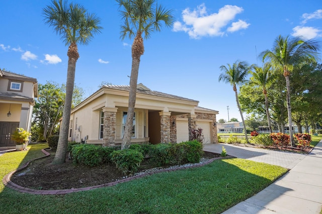 view of front of property with driveway, an attached garage, stucco siding, a front lawn, and stone siding