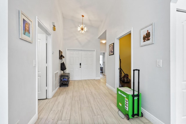 foyer featuring visible vents, baseboards, an inviting chandelier, and light wood finished floors