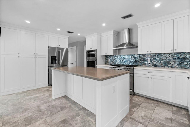 kitchen with visible vents, high quality appliances, a kitchen island, tasteful backsplash, and wall chimney exhaust hood