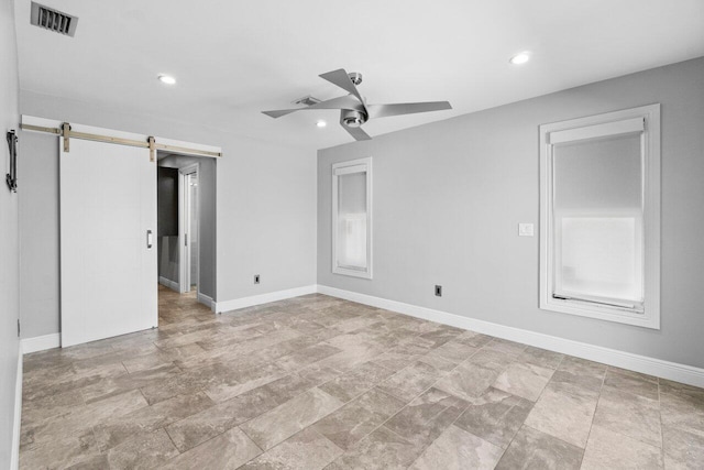 empty room featuring visible vents, ceiling fan, baseboards, a barn door, and recessed lighting