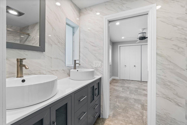 bathroom featuring double vanity, tile walls, and a sink