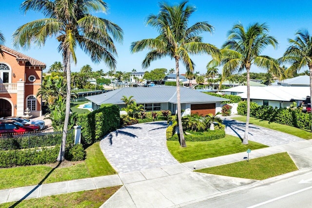 view of community featuring a residential view, a lawn, driveway, and fence