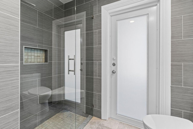 bathroom with a shower stall and toilet